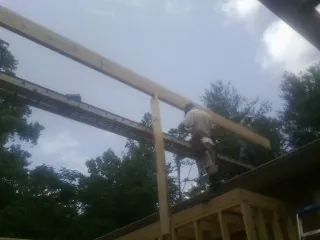 Carpenter setting a ridge beam over a new addition frame — Ice Dam Removal by Roofing Brothers in Lone Wolf