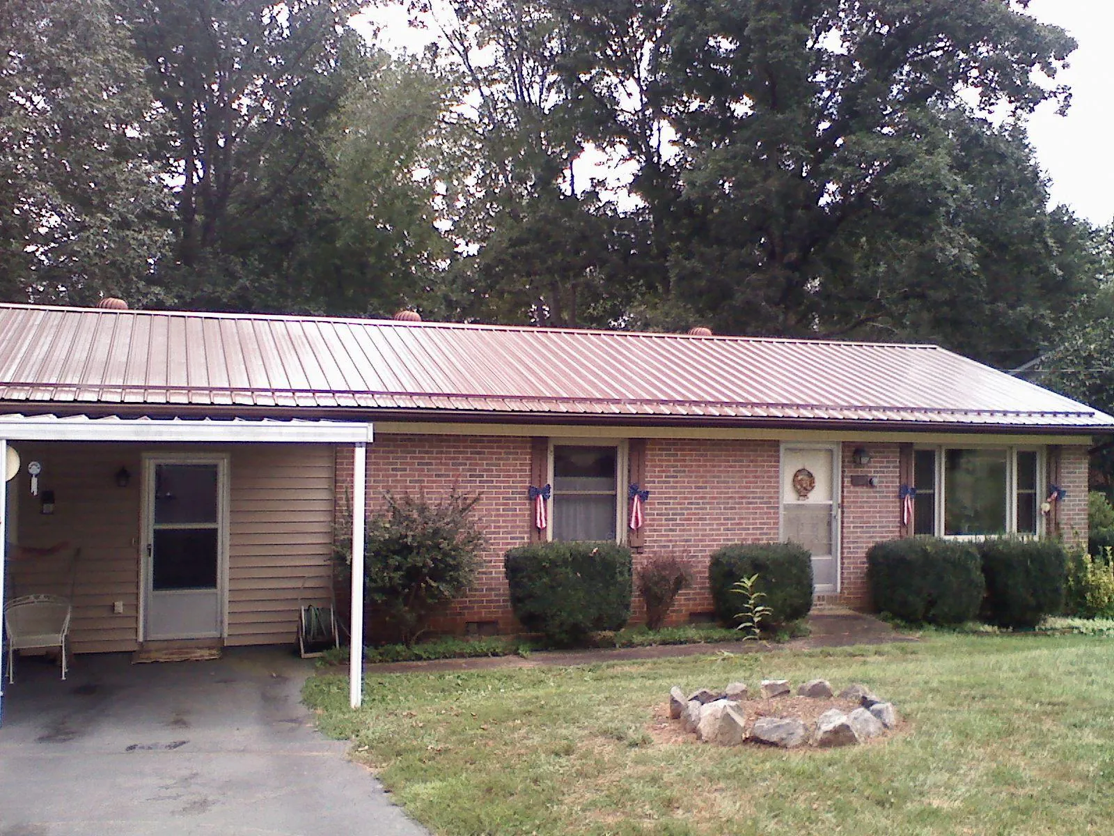Bronze metal roof and carport on a brick ranch home — Roof Repair work by our crew in Lone Wolf