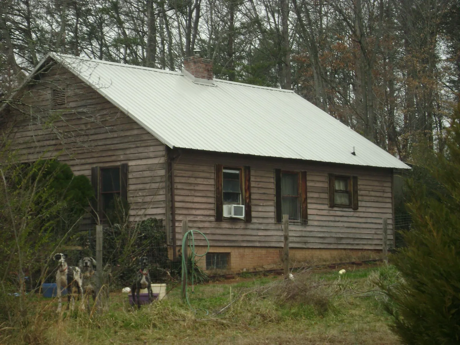 White metal roof on an old wood sided farmhouse, from a Metal Roof Installation job in Lone Wolf